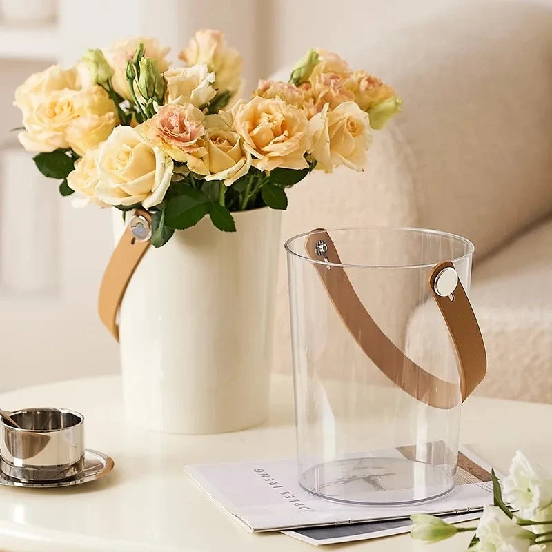 Two Acrylic Cylinder Vases with roses inside standing on a coffee table