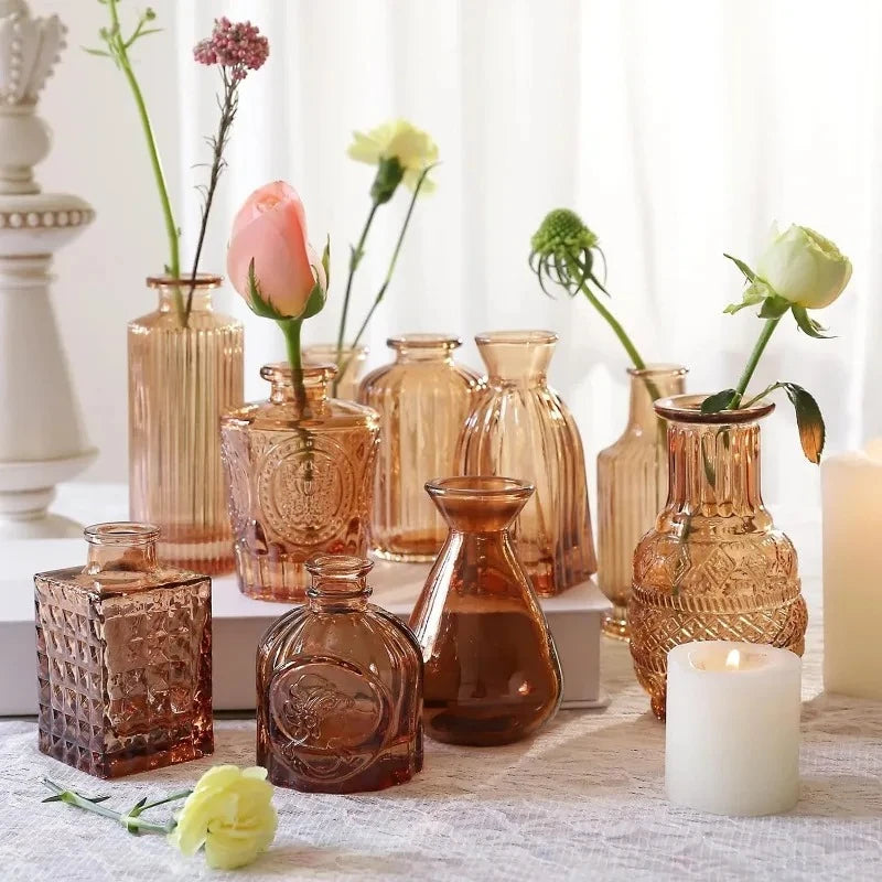 Amber vases on a table next to decorational elements and flowers