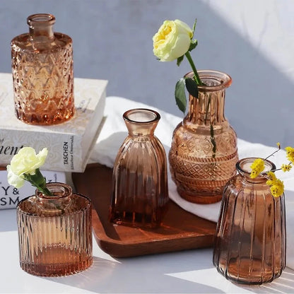 Amber Vases on a wooden tray with flowers inside next to decorational elements