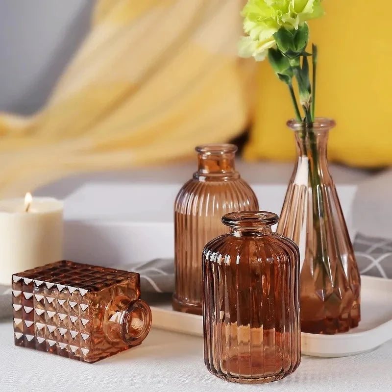 Four Amber Vases on a white tray next to a candle