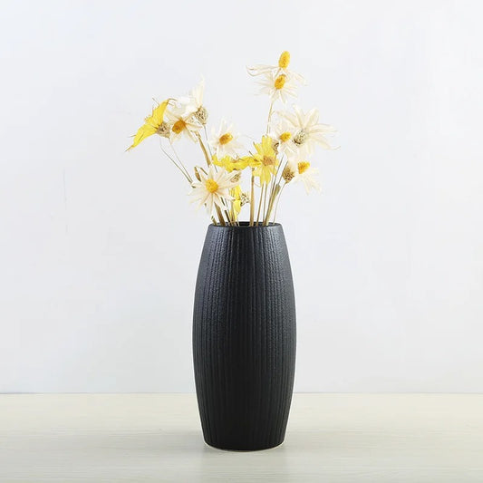 Black Bud Vase with yellow flowers inside on a white background