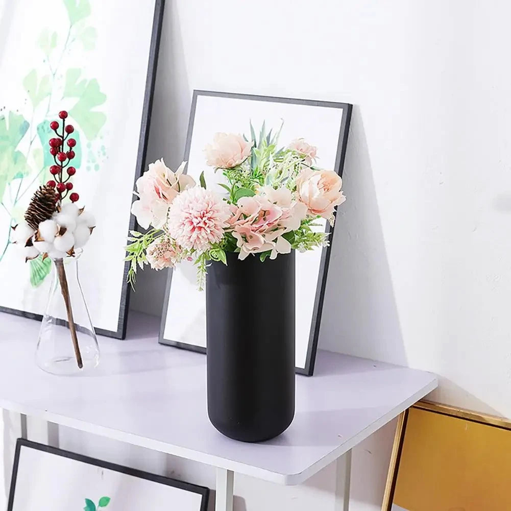 Black Cylinder Vase on a white table with flowers inside