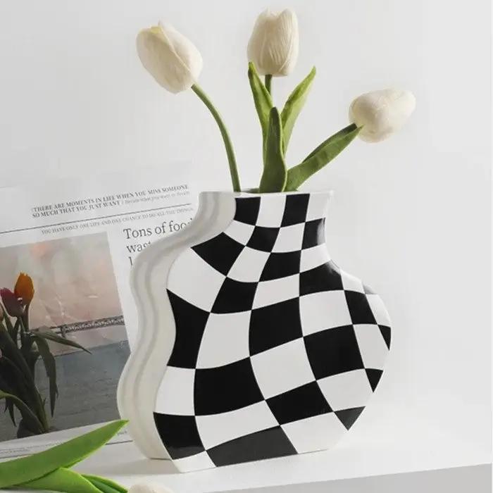 Black and White Vase with white tulips inside on a white surface