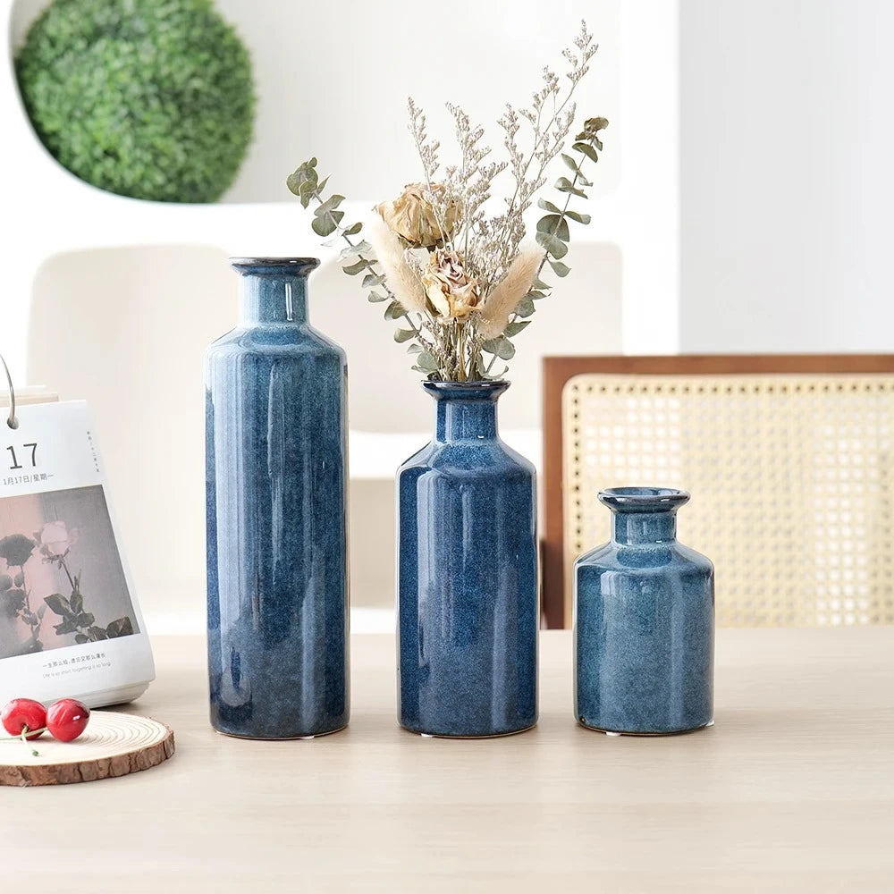 Blue Bud Vases on a beige table with decorative elements next to it