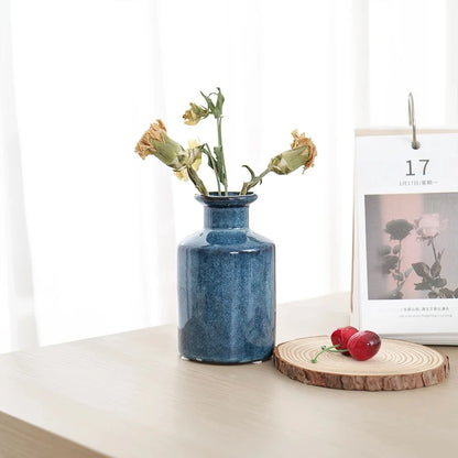 Small Blue Bud Vase on a wooden table next to a calendar