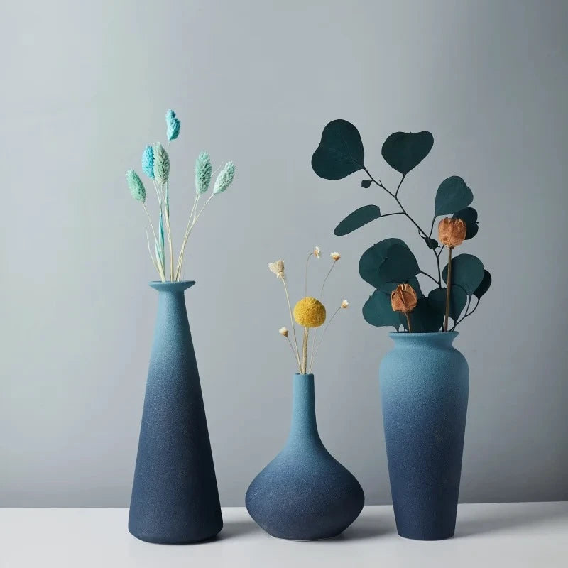 Three Blue Ceramic Vases with flowers inside