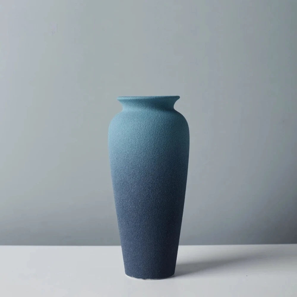 Bottle shaped Blue Ceramic Vase on a white surface