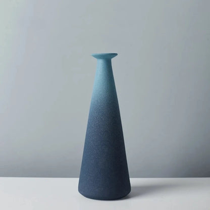 Long shaped Blue Ceramic Vase on a white surface