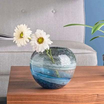 Blue Round Vase standing on a wooden coffee table in front of a sofa 