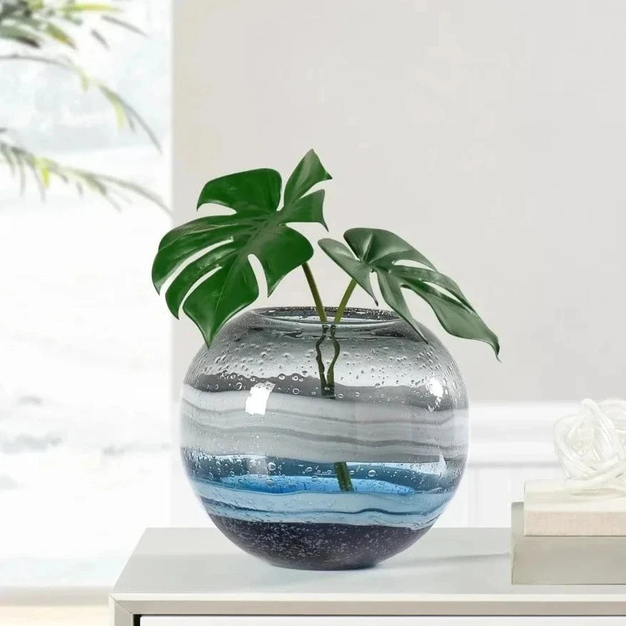 Blue Round Vase standing on a white desk with greenery inside