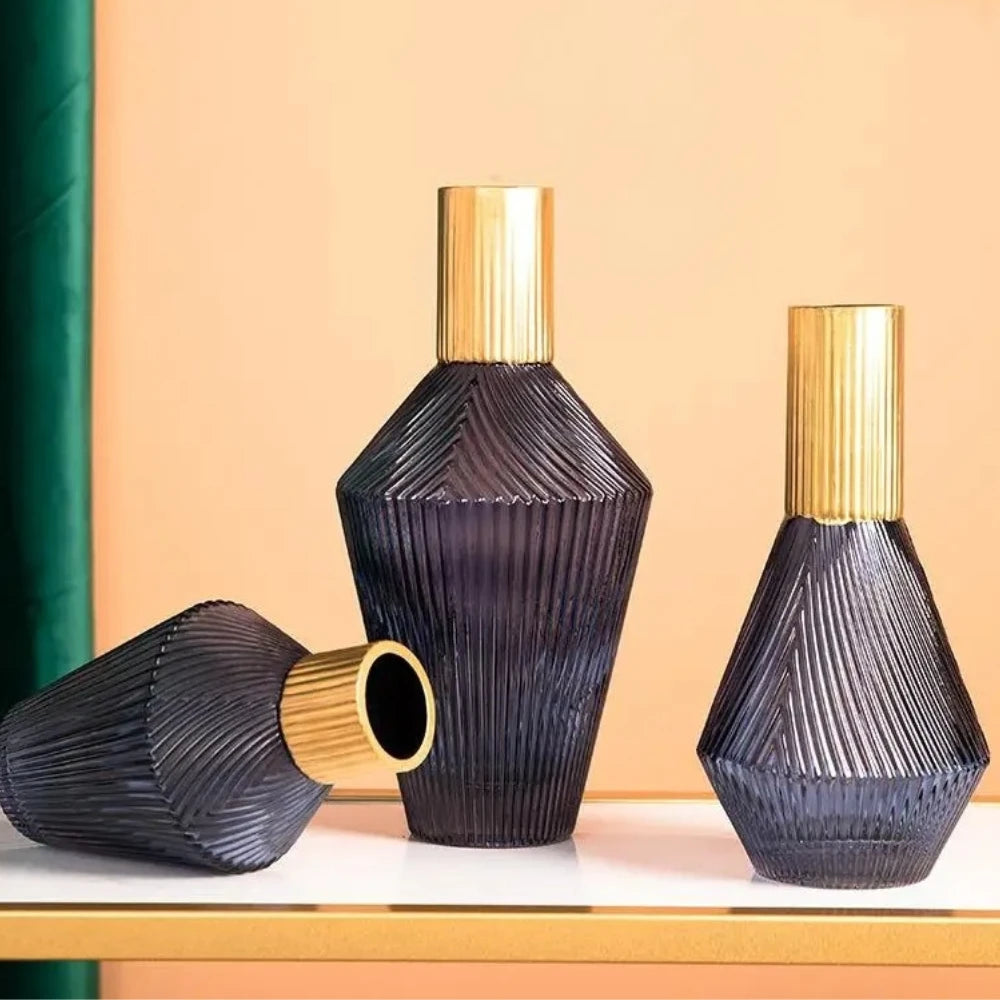 Three Blue and Gold Vases on a white surface in front of a beige wall