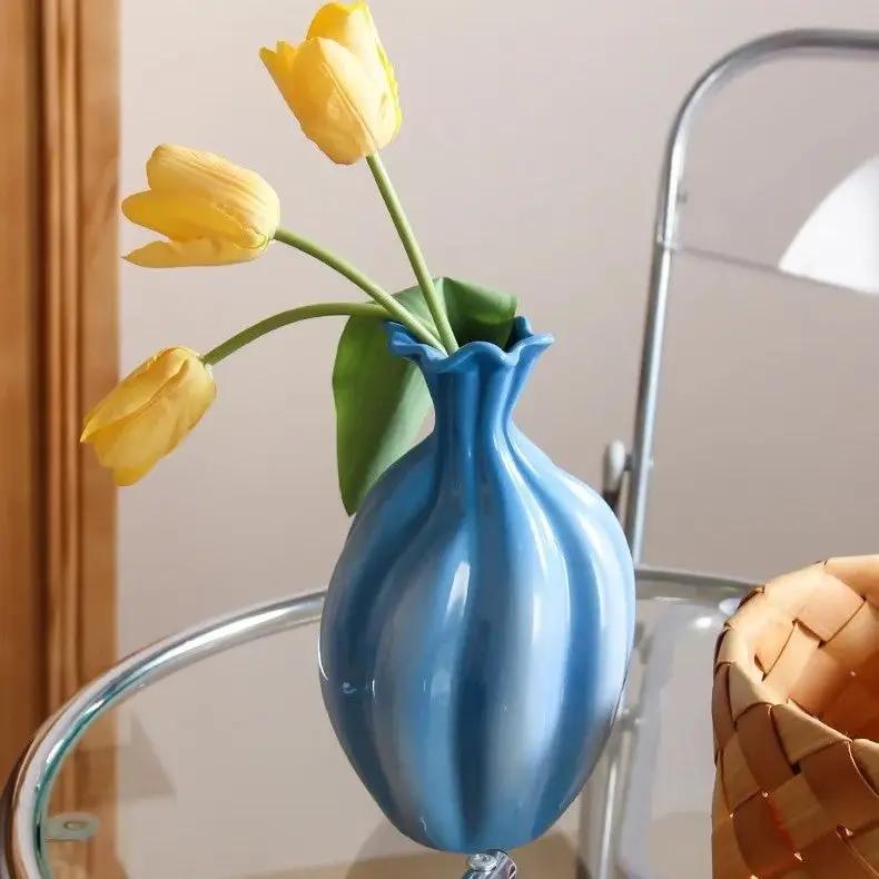 Blue and White Vase with yellow flowers inside on a glass table