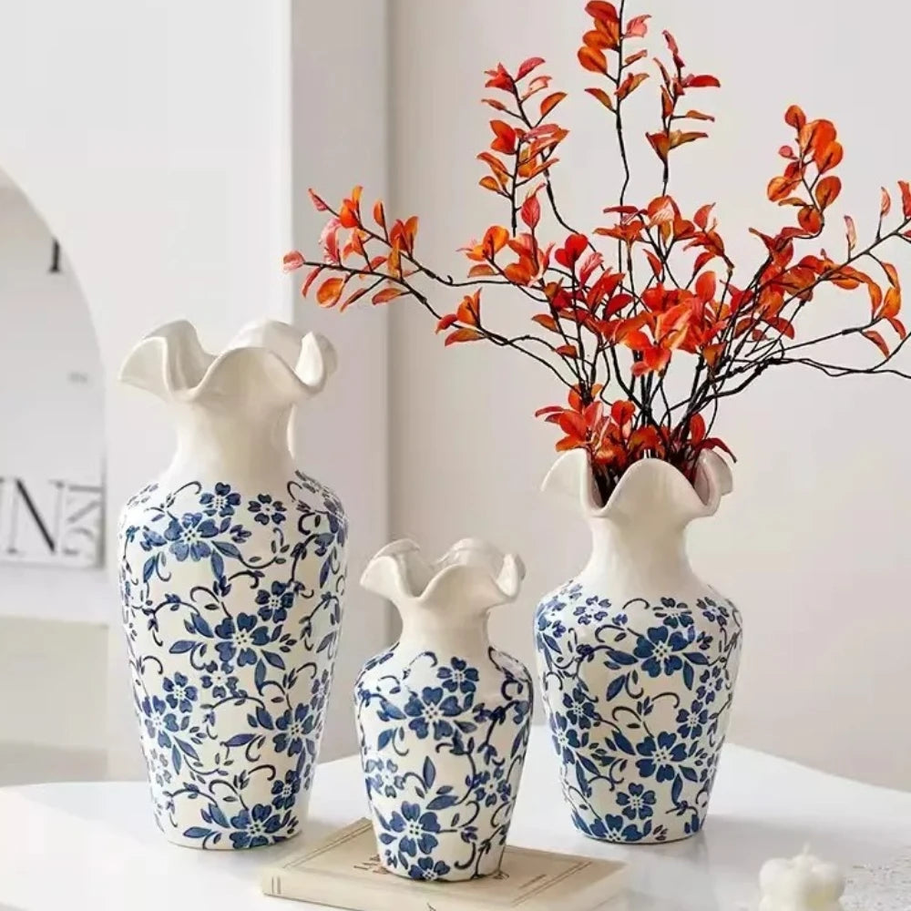 Three Blue and White Vases with red plants inside