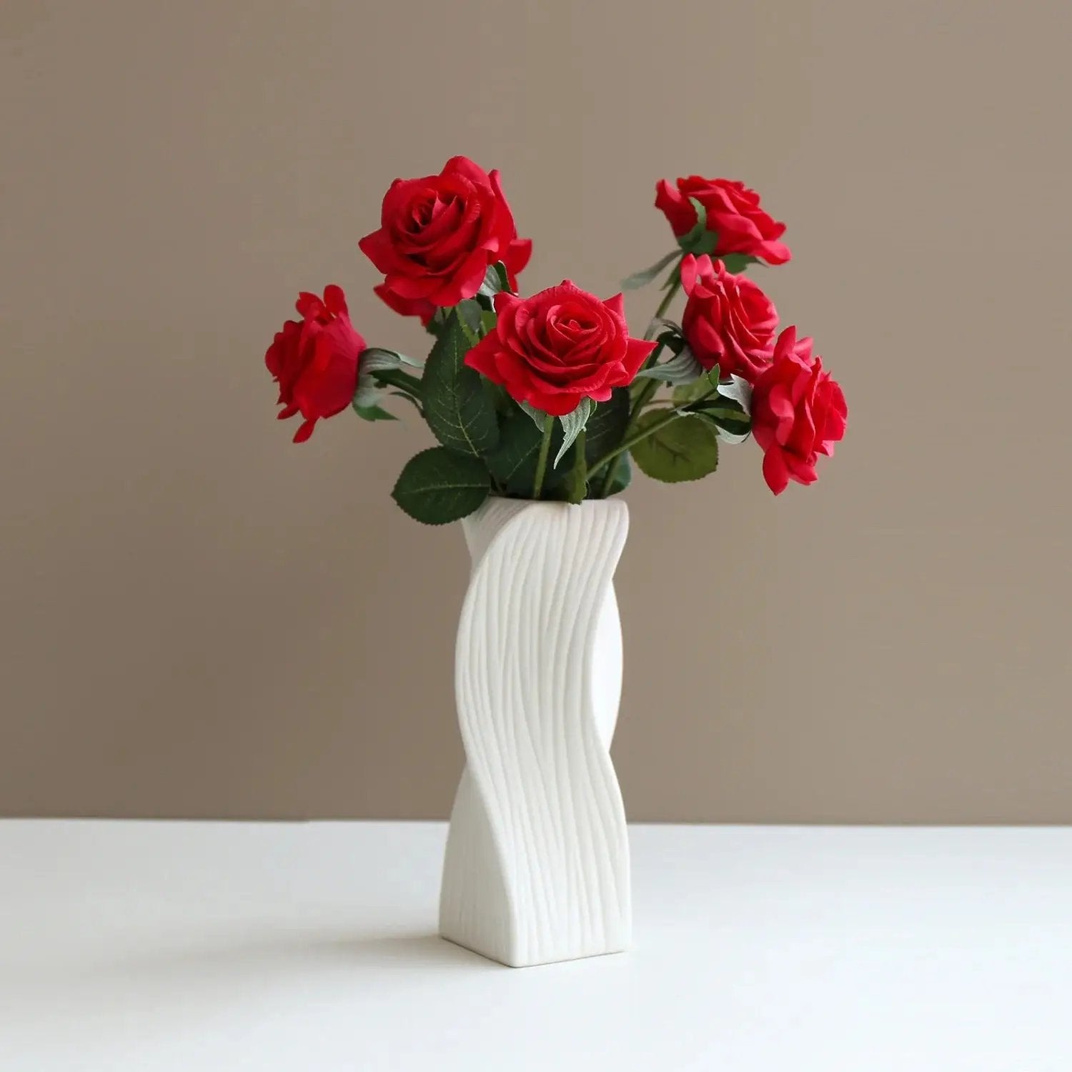 Large Ceramic Bud Vase on a white shelf on a brown background with roses inside