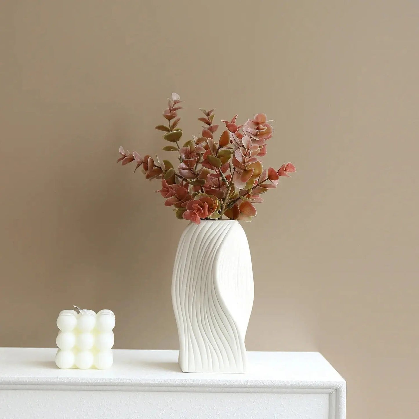 Medium sized Ceramic Bud Vase on a brown background on a shelf next to a candle