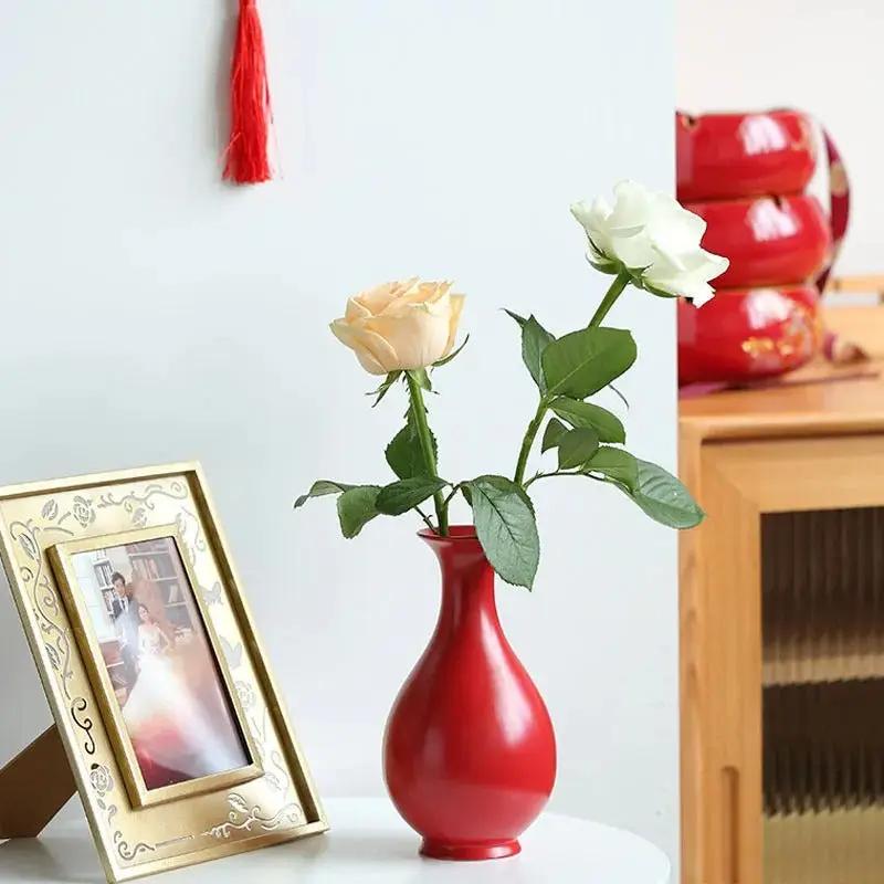 Chinese Red Vase With Flowers Inside Next To a Picture Frame