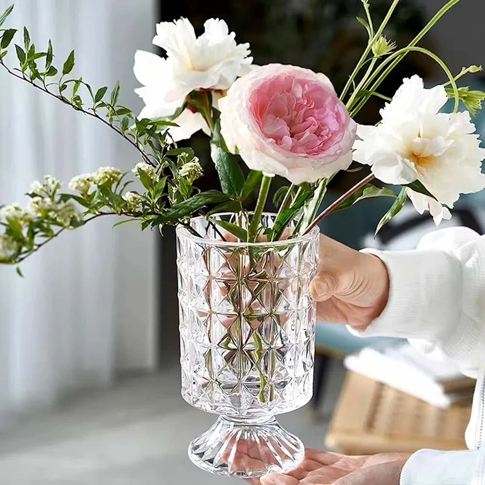 Person holding a Crystal Pedestal Vase with flowers inside