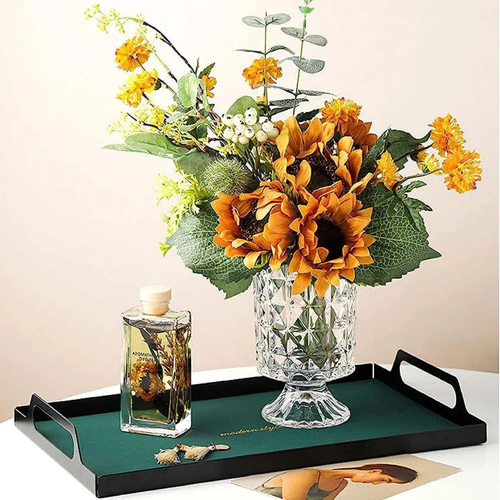 Crystal Pedestal Vase on a green tray with yellow flowers inside next to a perfum