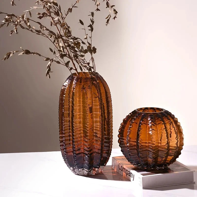 Two Dark Brown Vases on a white surface with decorational elements inside of them