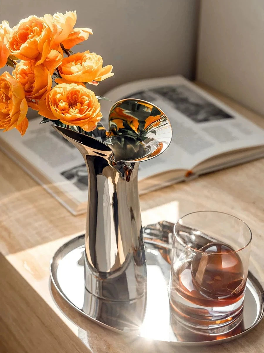 Flower Metal Vase on a silver tray with orange flowers inside