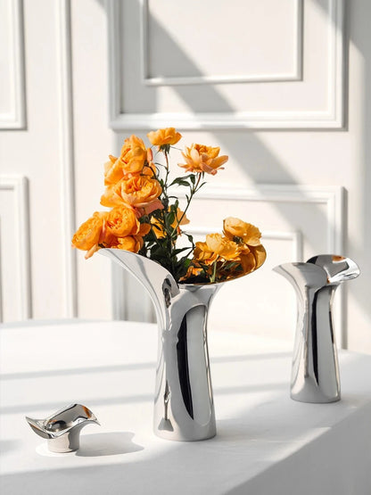 Two Flower Metal Vases with orange flowers inside