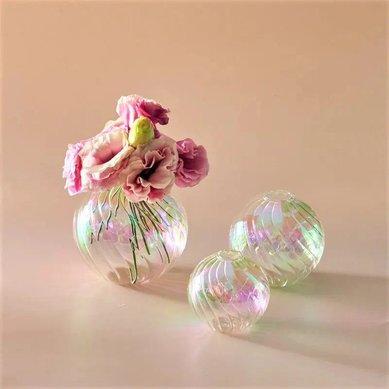 Clear Glass Round Vases with flowers inside on a peach surface