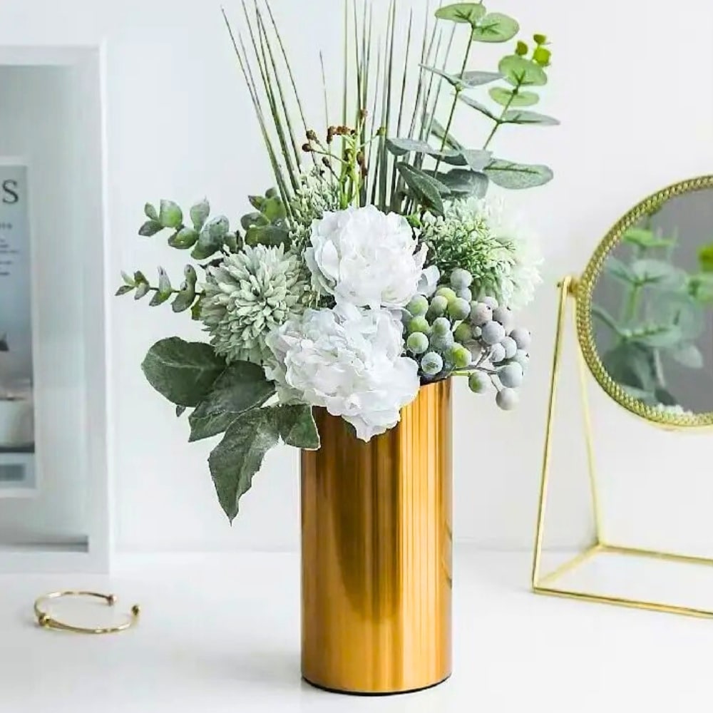 Gold Cylinder Vase With Flowers inside of it