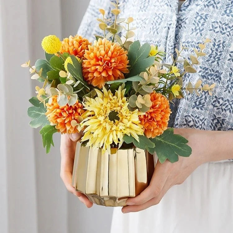 Person holding a Golden Vase with flowers inside