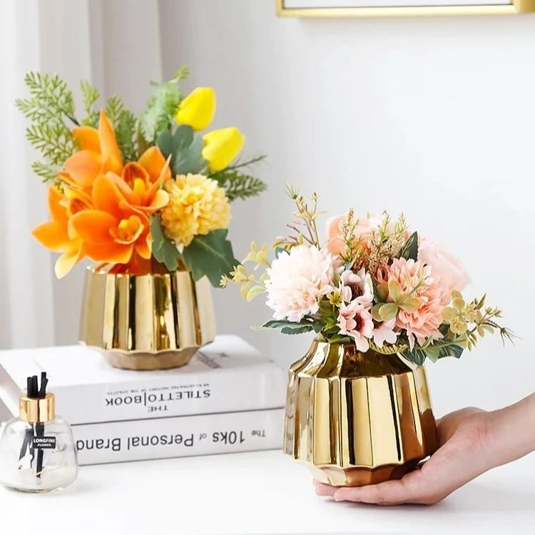 Person holding a Golden Vase with another Golden Vase next to it sitting on a book