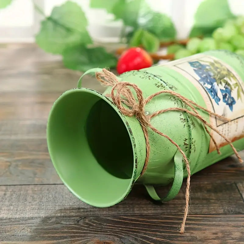 Green Metal Vase laying on the side on a wooden table