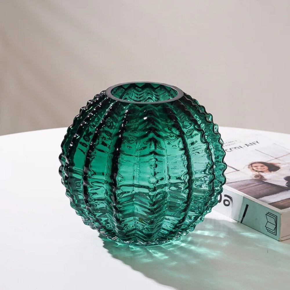 Green Round Vase on a white surface next to a book