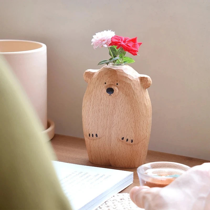 Hand Carved Wooden Vase with red flowers inside on a wooden table