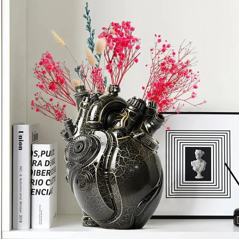 Heart Vase with red flowers inside standing in a shelf next to decorational elements