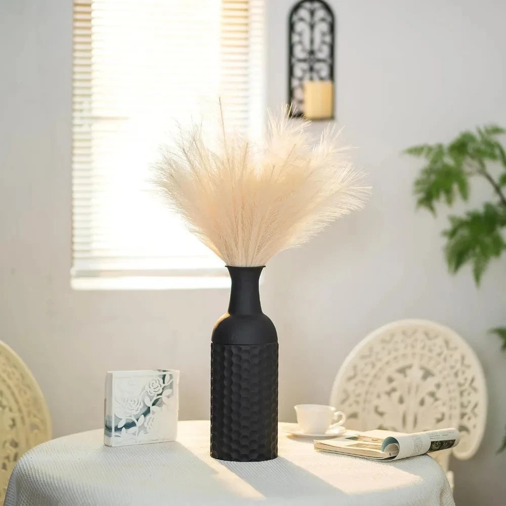 Large Black Vase on a table with chairs next to it