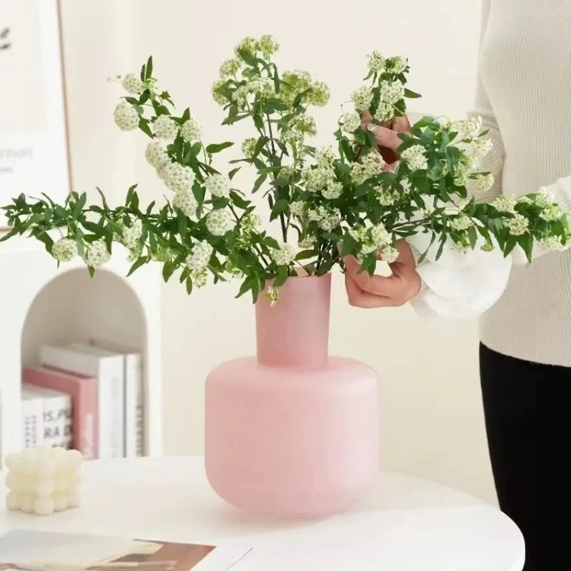 Light Pink Vase with greenery inside on a white round table