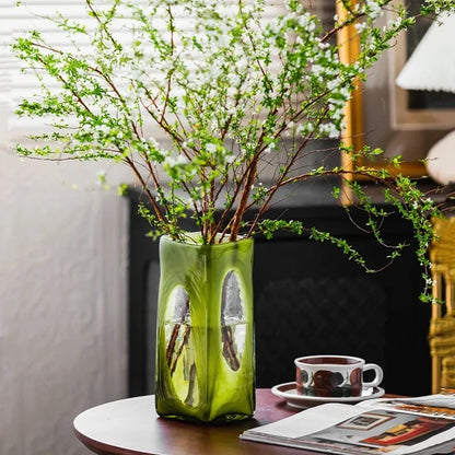 Lime Green Vase with greenery inside on a wooden coffee table