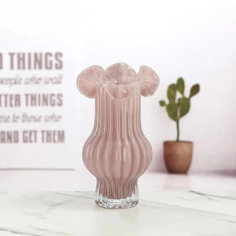 Red Milk Glass Bud Vase on a white marble surface with a plant in the background