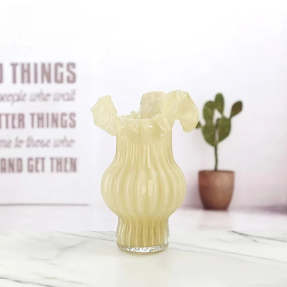 Yellow Milk Glass Bud Vase on a white marble surface with decoration in the background