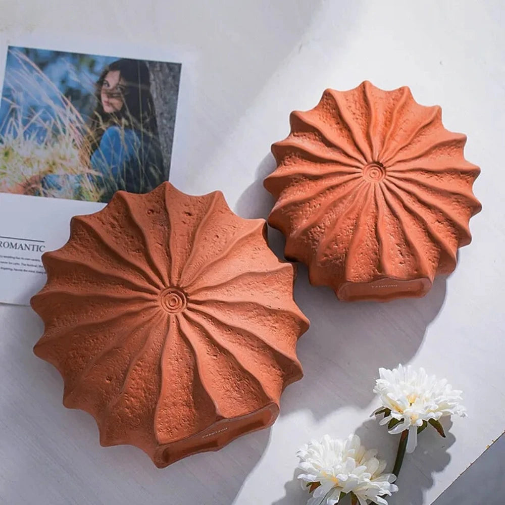 Two Orange Vase Decor sets on a white surface next to a picture and flowers