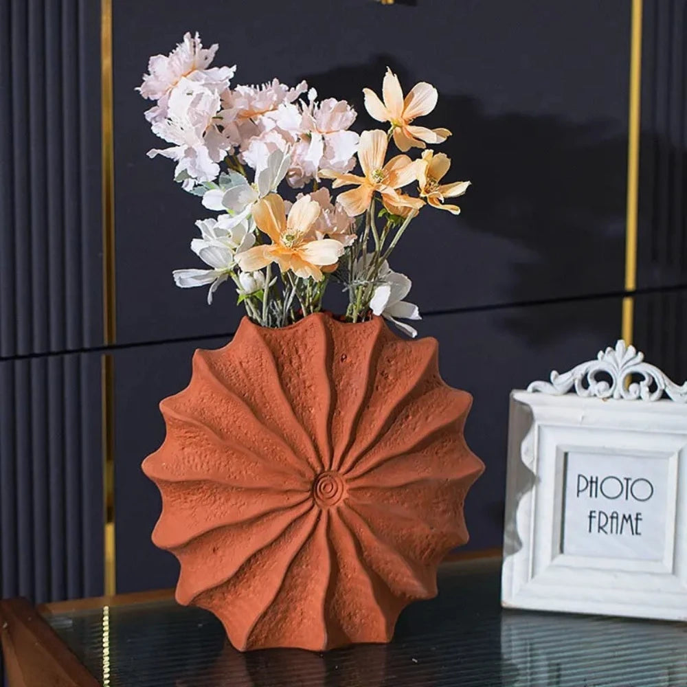 Orange Vase Decor set with flowers inside on a shiny black surface