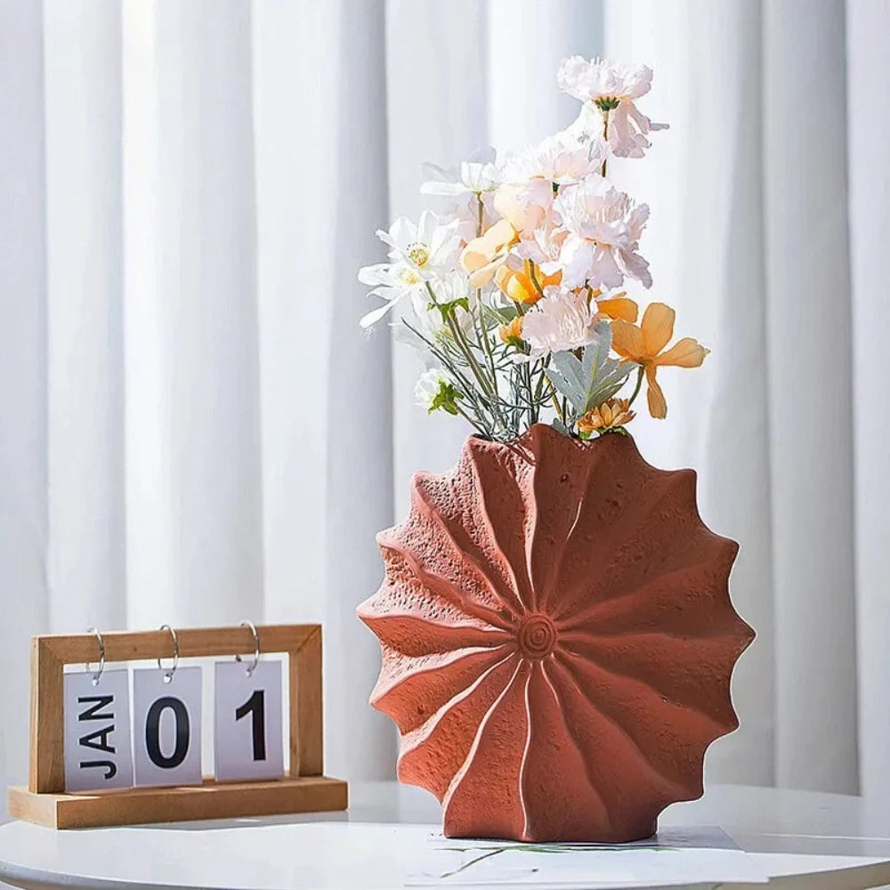 Orange Vase Decor set on a white surface with flowers inside next to a calendar