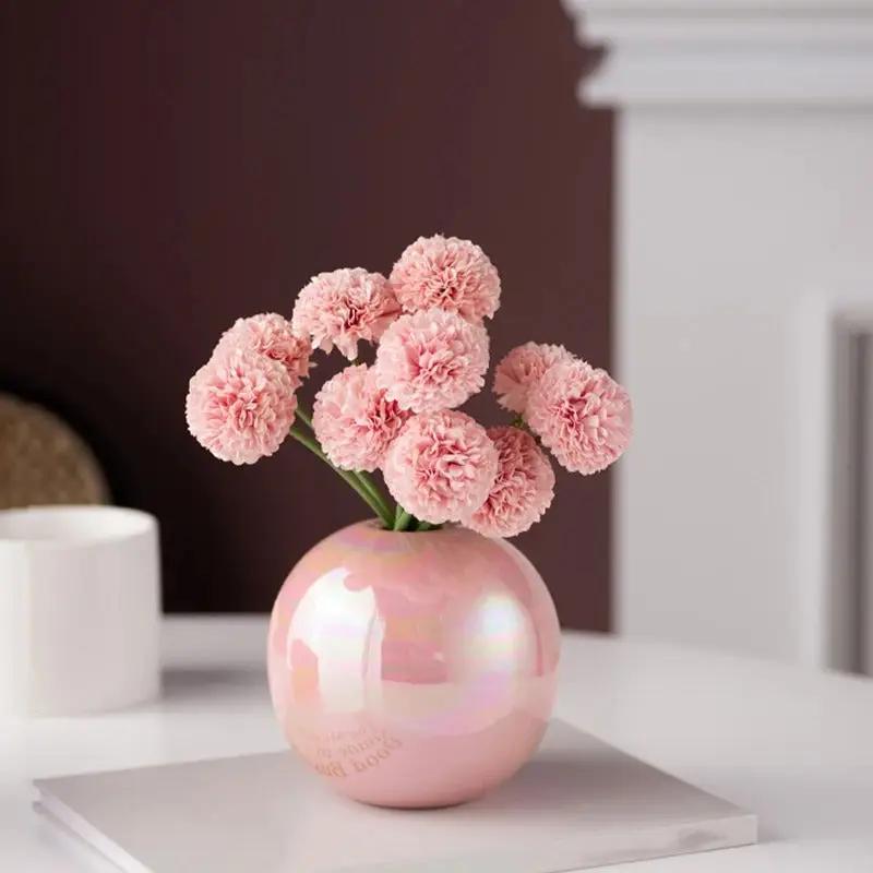 Pink Bud Vase standing on a white table with pink flowers inside