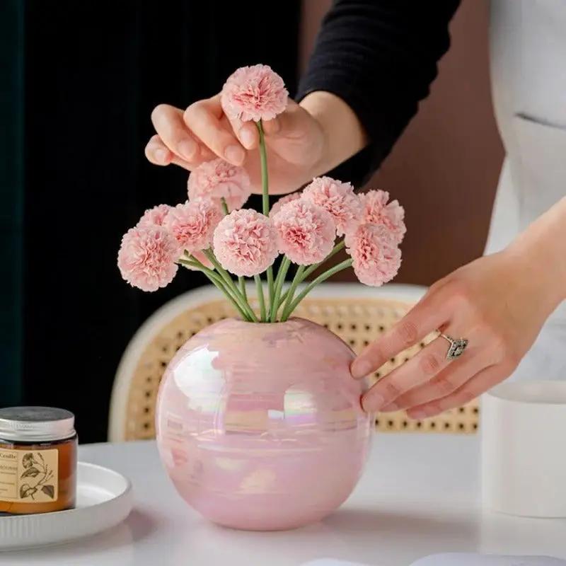 Person putting pink flowers into a Pink Bud Vase