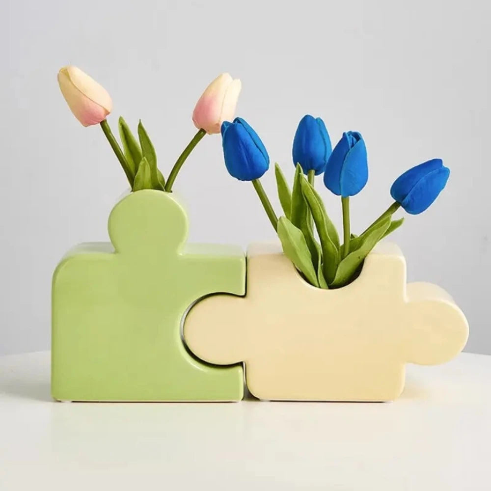 Two Puzzle Vases with flowers inside on a white surface