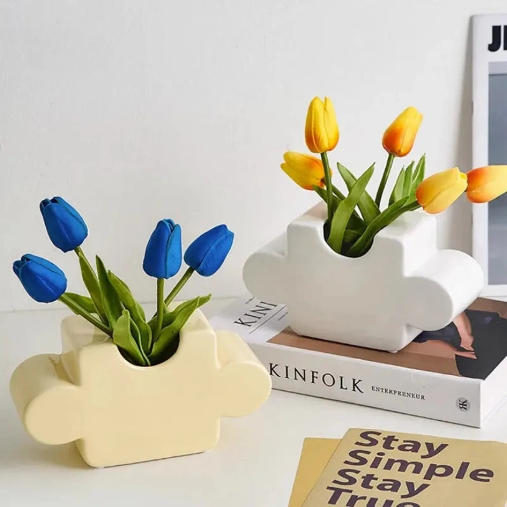 Two Puzzle Vases with blue and orange tulips inside on a white surface