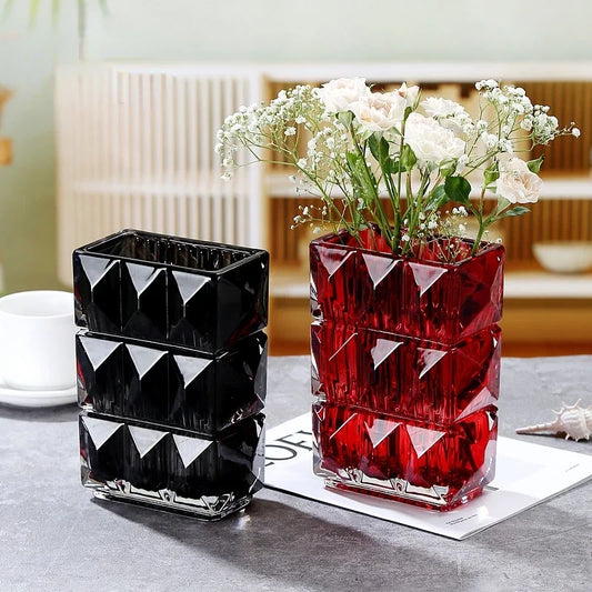 Red and Black Vases standing on a gray table with decorative elements underneath them