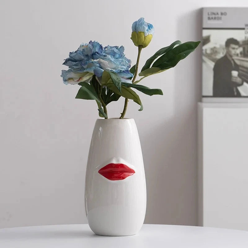 Red and White Vase with blue flowers inside on a white surface