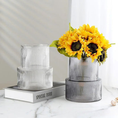 Two Short Cylinder Vases standing on a book on a white marble table