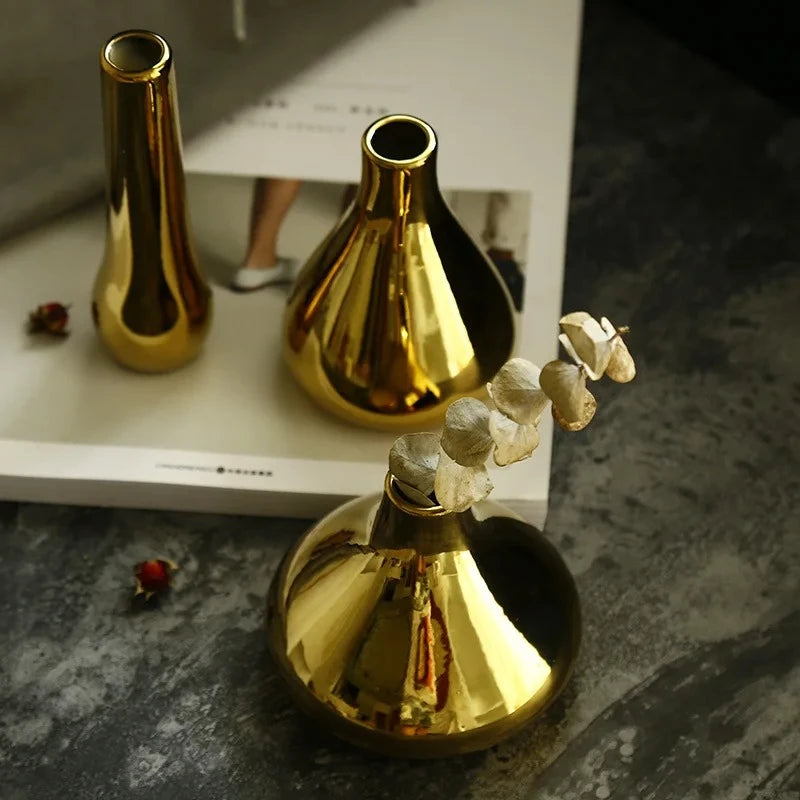 Three Small Gold Vase with dried flowers inside on a gray surface