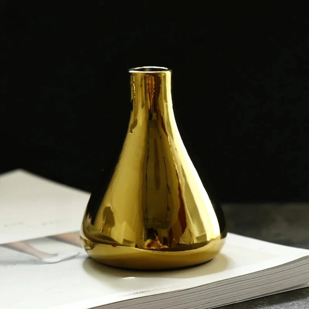 Small Gold Vase on a white surface on a dark background